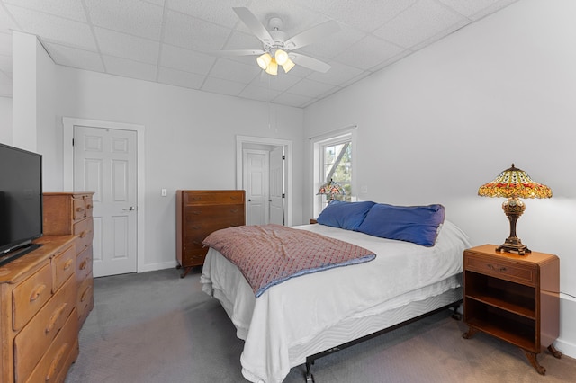 bedroom featuring carpet floors, a ceiling fan, baseboards, and a paneled ceiling