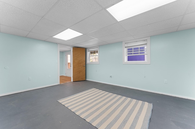 below grade area with baseboards and a drop ceiling