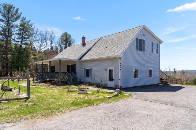 rear view of house featuring roof with shingles, aphalt driveway, a porch, stairway, and a chimney