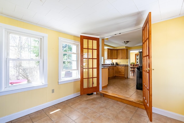 doorway featuring baseboards, light tile patterned flooring, and visible vents