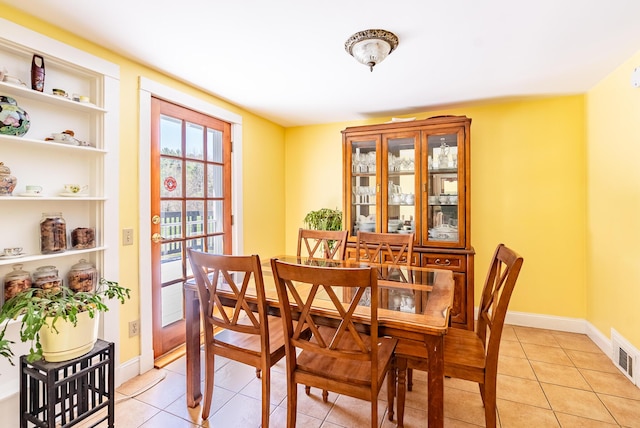 dining area with baseboards, light tile patterned floors, and visible vents