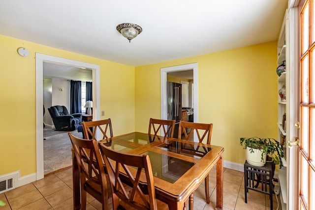 dining space with baseboards, visible vents, and light tile patterned floors