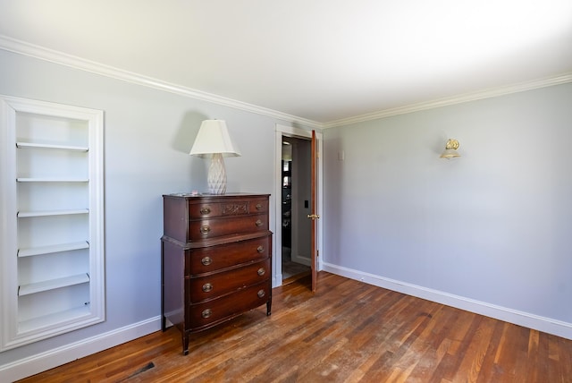 bedroom with baseboards, ornamental molding, and wood finished floors