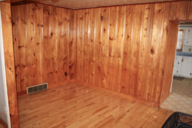 spare room featuring visible vents, a sauna, wood finished floors, and wooden walls
