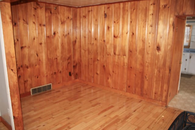 spare room featuring wood walls, visible vents, wood finished floors, and a sauna