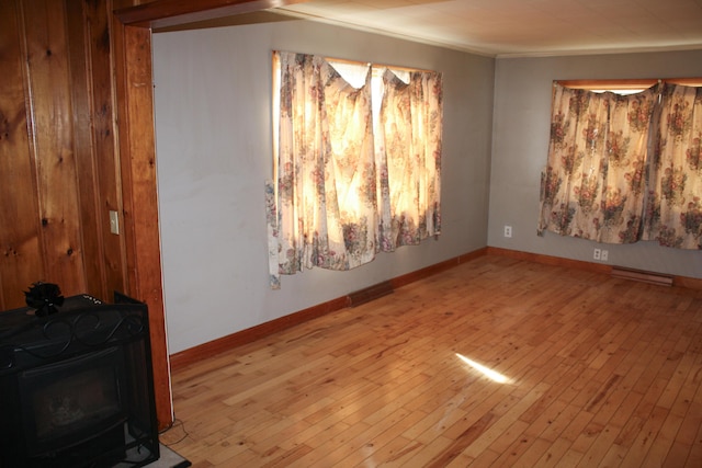 spare room featuring baseboards, crown molding, and hardwood / wood-style flooring