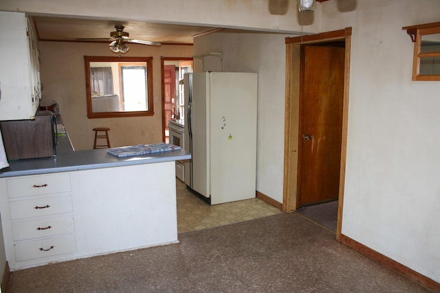 kitchen with white appliances, baseboards, light floors, white cabinets, and a ceiling fan