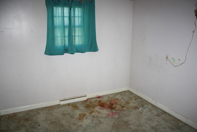 empty room with visible vents, concrete floors, and baseboards
