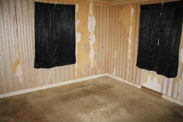 spare room with baseboards and unfinished concrete floors