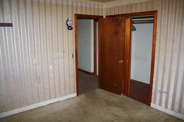carpeted spare room with baseboards and wallpapered walls