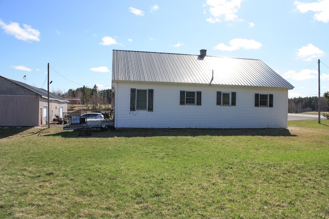 rear view of property with a yard and metal roof