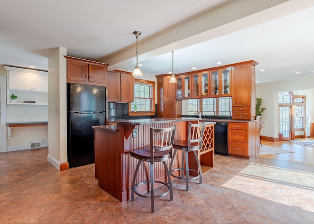 kitchen featuring visible vents, brown cabinetry, and black appliances