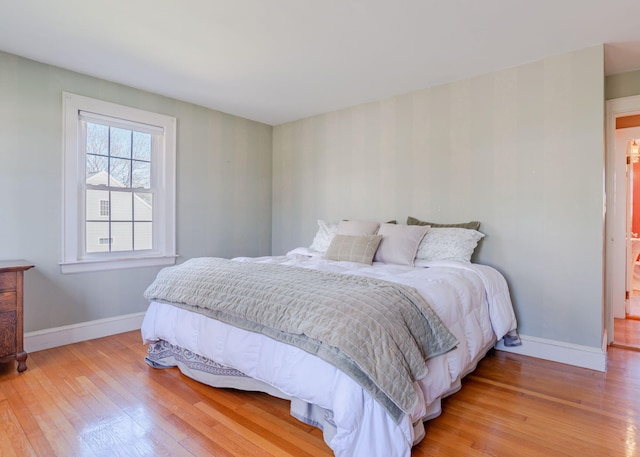 bedroom featuring light wood-style floors and baseboards