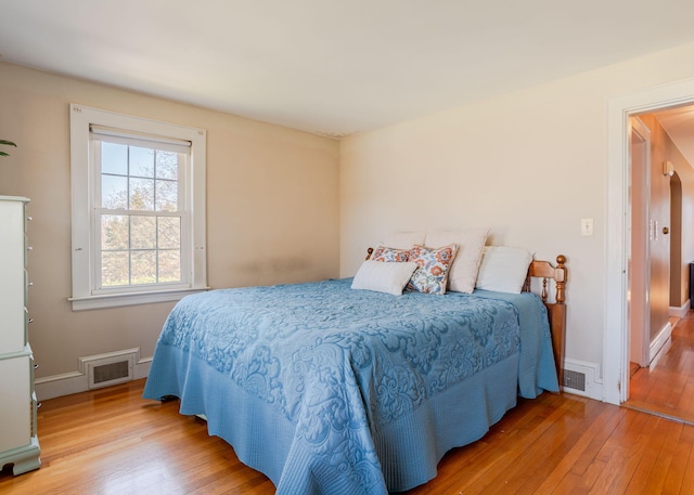 bedroom featuring baseboards, visible vents, and hardwood / wood-style flooring