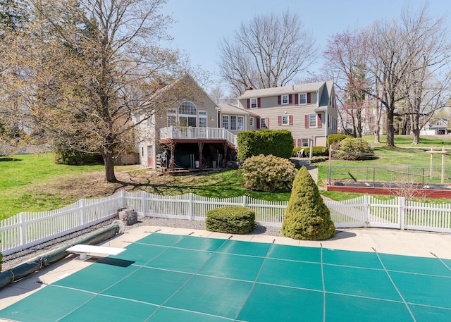 back of property with a lawn and fence