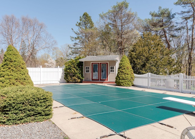 view of swimming pool featuring a fenced in pool, a storage structure, an outbuilding, and fence