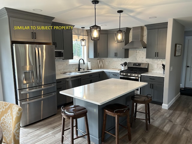 1215 Milton Mills Rd, Acton, ME 04001 - kitchen with wall chimney range hood, appliances with stainless steel finishes, a sink, and wood finished floors