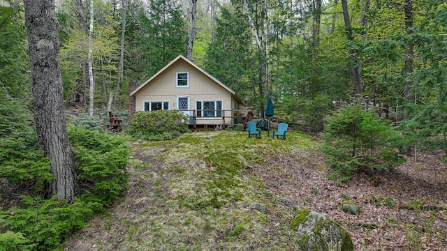 65 Pinecroft Rd, Harrison, ME 04040 - rear view of property featuring a wooden deck, a forest view, and a chimney