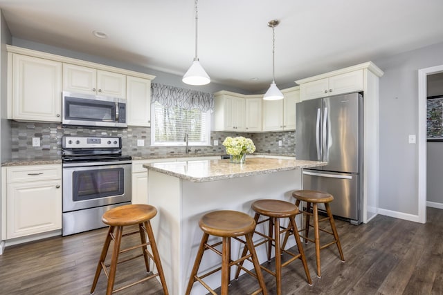 7 Berry Ln Unit 101, Biddeford, ME 04005 - kitchen featuring appliances with stainless steel finishes, a sink, a kitchen island, dark wood-style floors, and baseboards