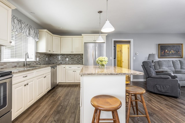 7 Berry Ln Unit 101, Biddeford, ME 04005 - kitchen with stainless steel appliances, dark wood-style flooring, open floor plan, a center island, and backsplash