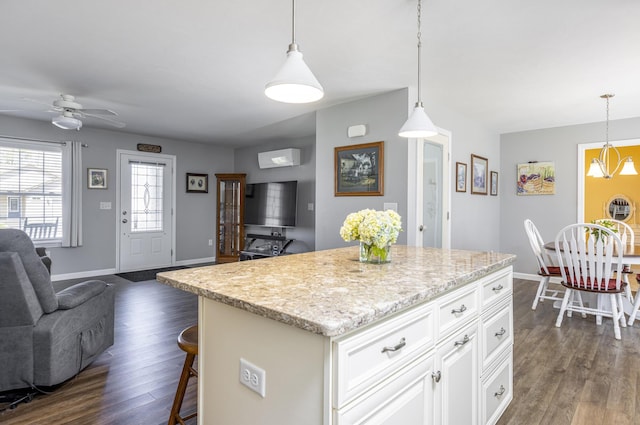 7 Berry Ln Unit 101, Biddeford, ME 04005 - kitchen featuring open floor plan, dark wood-style floors, ceiling fan, baseboards, and a breakfast bar