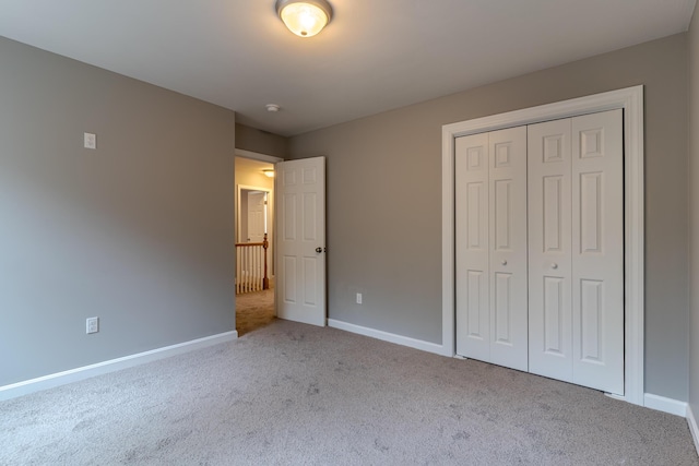 unfurnished bedroom with baseboards, a closet, and carpet