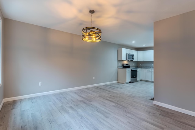 interior space featuring baseboards, a notable chandelier, light wood-style flooring, and recessed lighting