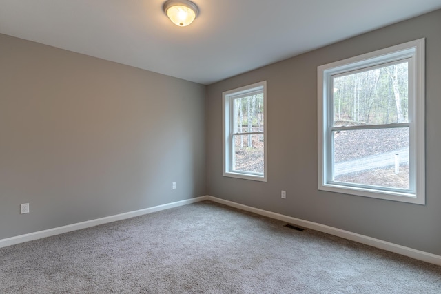carpeted empty room with baseboards and visible vents