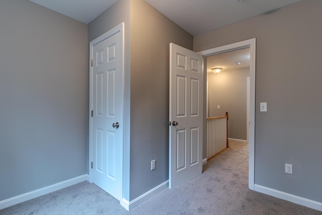 unfurnished bedroom featuring carpet flooring and baseboards