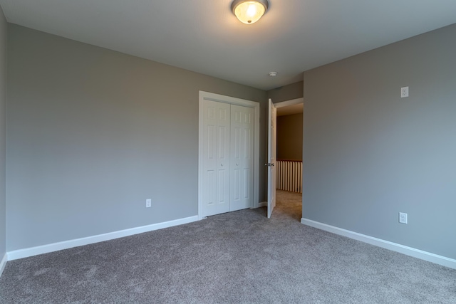 unfurnished bedroom with carpet, a closet, and baseboards