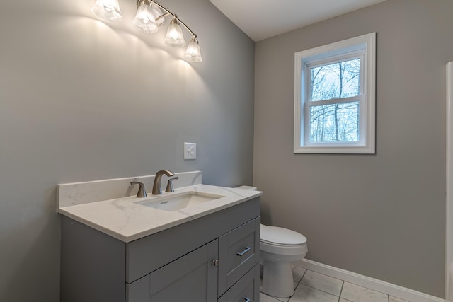 bathroom featuring toilet, marble finish floor, baseboards, and vanity