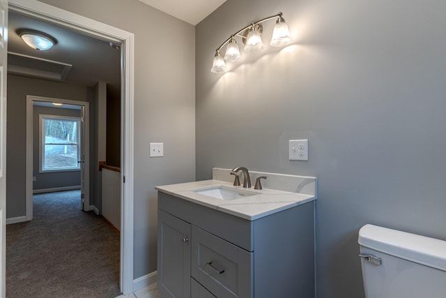 half bath with vanity, toilet, and baseboards