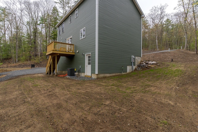 view of property exterior featuring central air condition unit and a deck