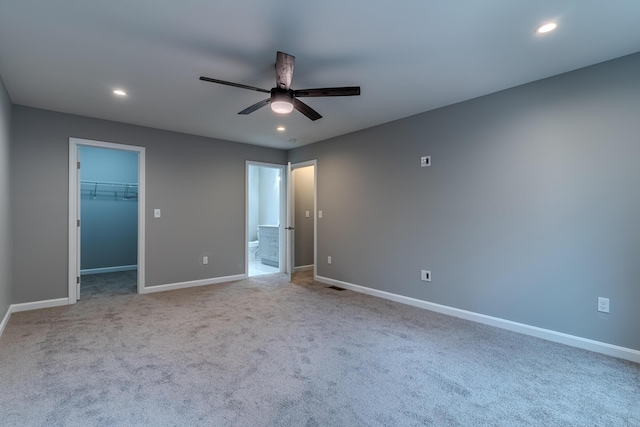 unfurnished bedroom with baseboards, carpet floors, a spacious closet, and recessed lighting