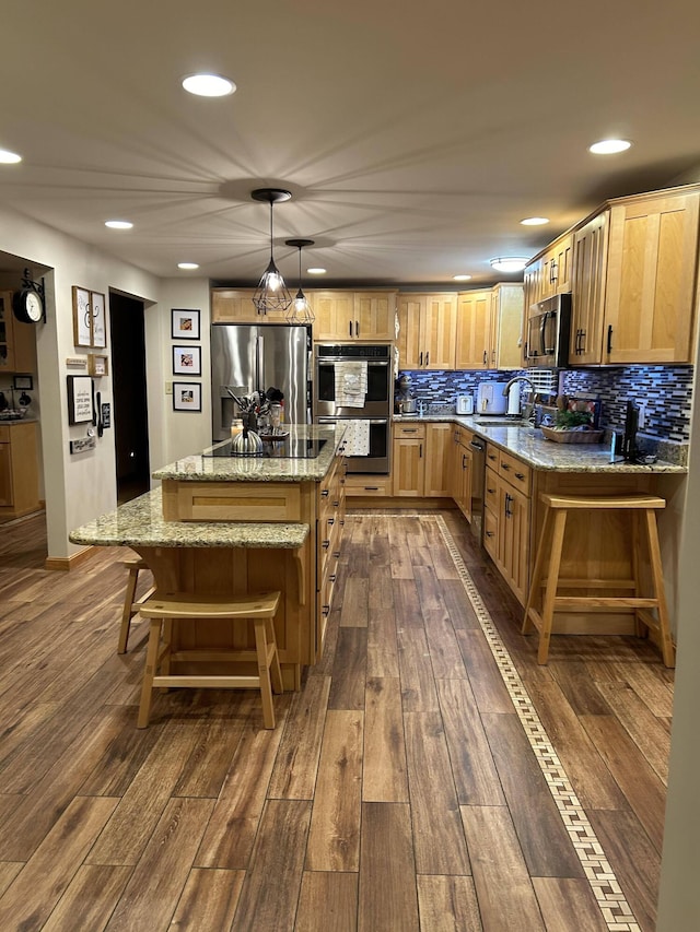 208 N Caribou Rd, Presque Isle, ME 04769 - kitchen with appliances with stainless steel finishes, decorative backsplash, a center island, and dark wood-style flooring