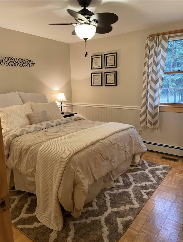 208 N Caribou Rd, Presque Isle, ME 04769 - bedroom with a ceiling fan, wainscoting, and a baseboard heating unit