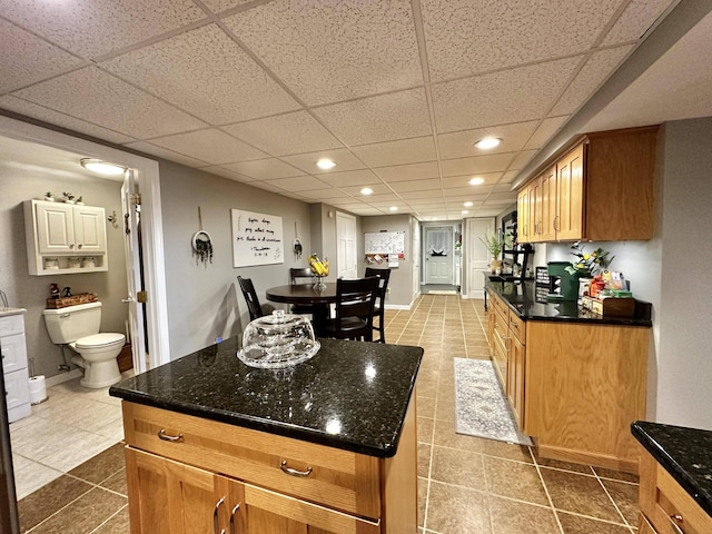 208 N Caribou Rd, Presque Isle, ME 04769 - kitchen with tile patterned flooring, dark stone countertops, and a paneled ceiling