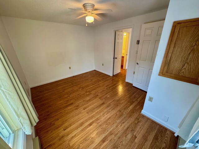 unfurnished bedroom featuring baseboards, ceiling fan, and wood finished floors
