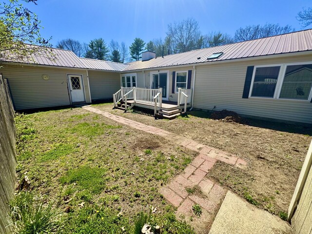 back of house with a wooden deck and metal roof