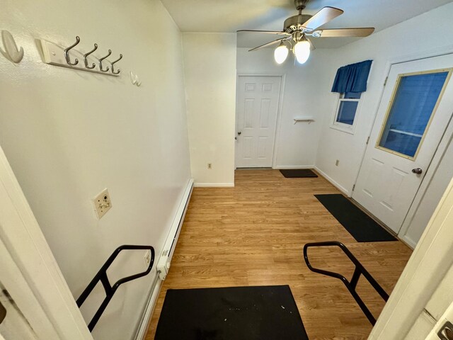 entryway featuring baseboards, ceiling fan, baseboard heating, and light wood-style flooring