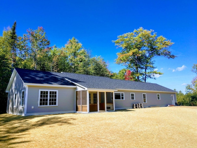 back of house with a sunroom and a shingled roof
