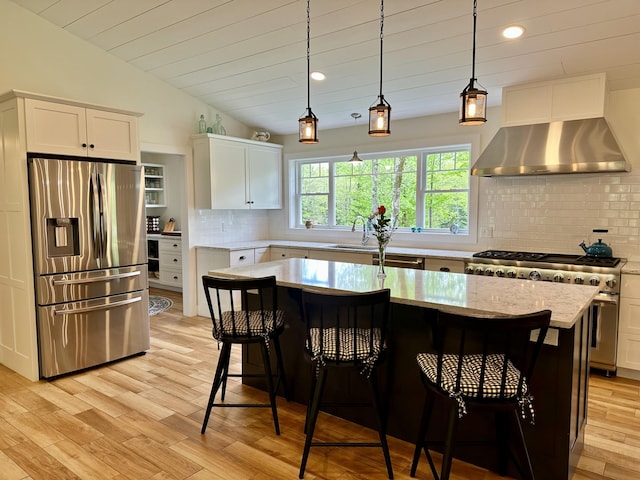 kitchen with stainless steel appliances, white cabinetry, range hood, decorative backsplash, and light wood-style flooring