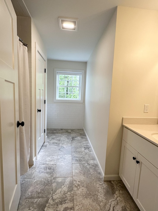 full bathroom featuring vanity and baseboards