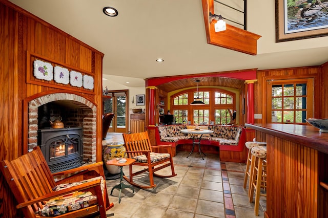 living area featuring recessed lighting, a wood stove, and wood walls