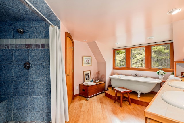full bathroom with a sink, tiled shower, wood finished floors, and a freestanding bath