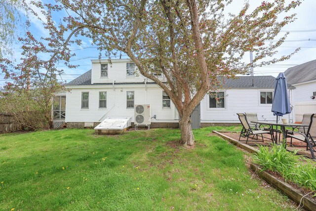 back of property featuring a sunroom and a lawn