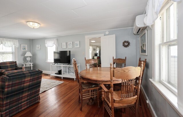 dining area featuring an AC wall unit, dark wood finished floors, and baseboards