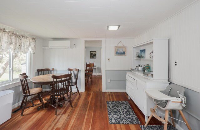 dining space featuring a wall unit AC, wood finished floors, and ornamental molding