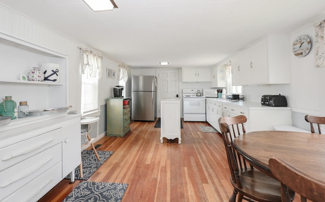 kitchen with white appliances, white cabinetry, light wood finished floors, light countertops, and ornamental molding