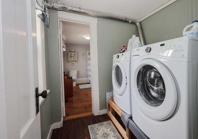 laundry area with dark wood-type flooring, washer and dryer, and baseboards